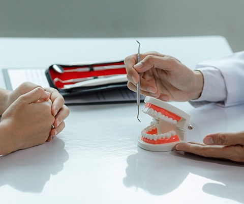 Dentist using model to explain concept to patient