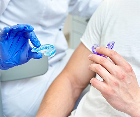 Dentist and patient holding nightguards